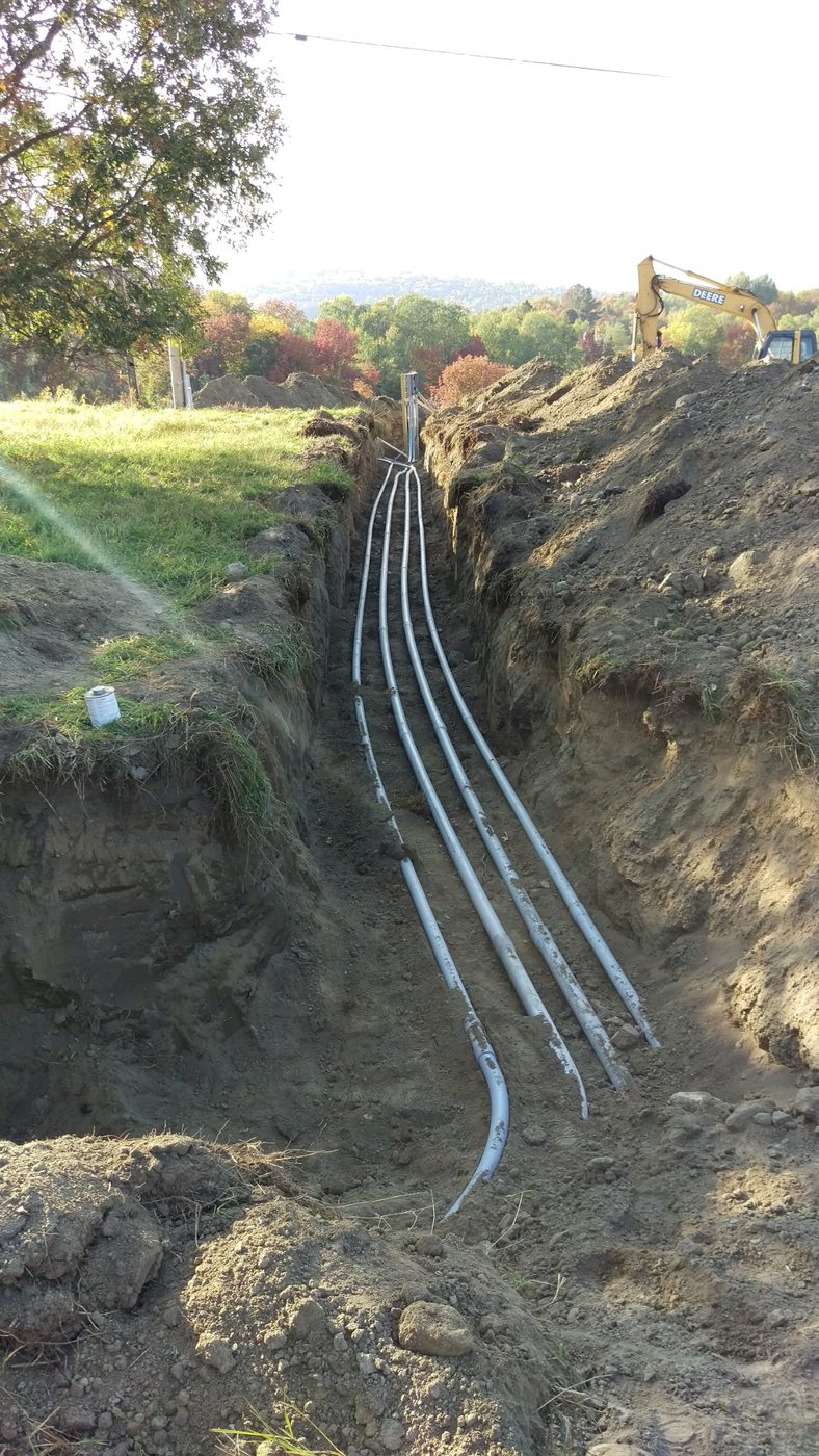 Underground electrical service conduit run in a trench across a property